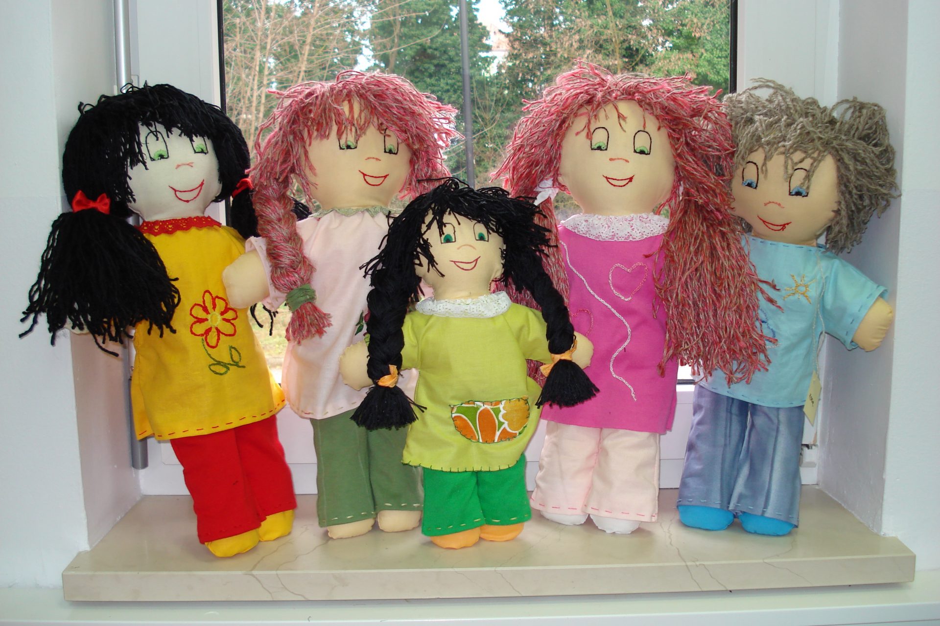Pet punčk igrač na oknu