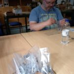 Fotografija prikazuje uporabnika in končne izdelke - paketki vijakov.