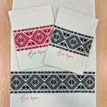 Kuhinjska krpa s potiskom belokranjskega vzorca v črni in rdeči barvi.