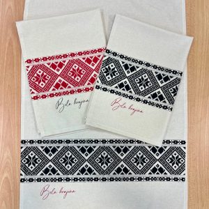 Kuhinjska krpa s potiskom belokranjskega vzorca v črni in rdeči barvi.